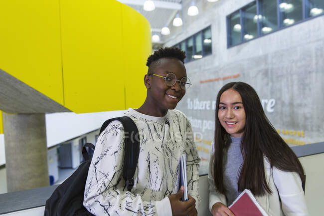 Retrato confiante júnior alunos do ensino médio no corredor — Fotografia de Stock
