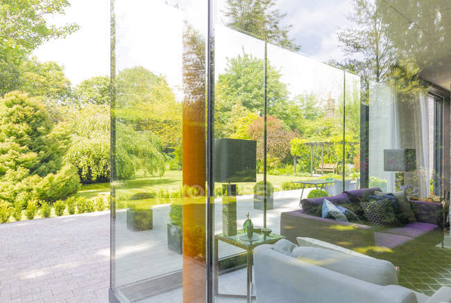 Casa moderna con finestre a tutta altezza e giardino paesaggistico — Foto stock