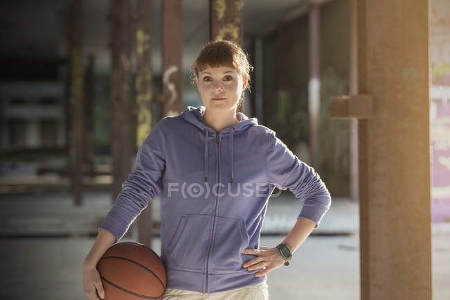 Спортсменка стоїть з баскетбольним м'ячем — стокове фото