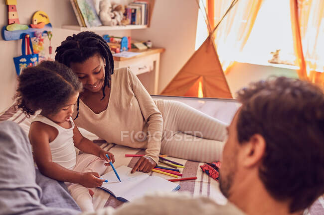 Familia joven para colorear en la cama - foto de stock
