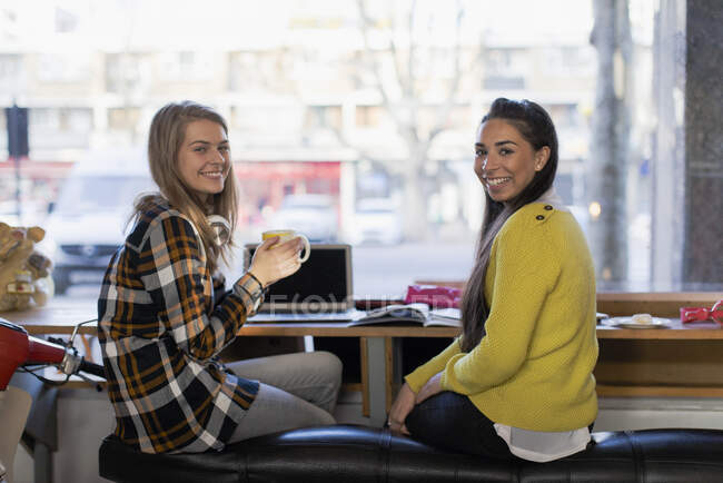 Ritratto fiducioso giovani studenti universitari femminili che studiano in caffè — Foto stock