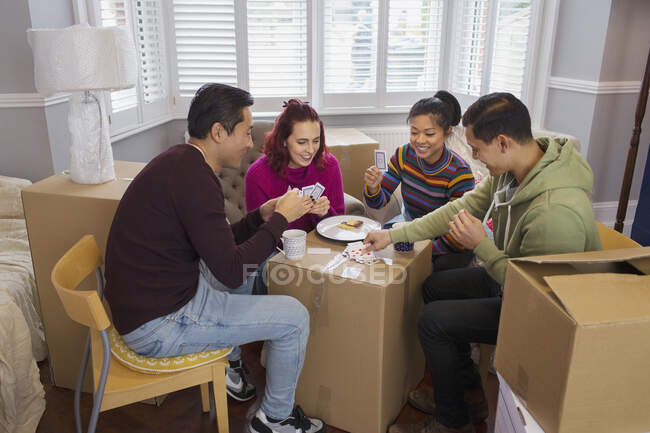 Friends taking a break from moving, playing cards — Stock Photo