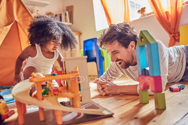 Father and toddler daughter playing with toys on floor — Stock Photo
