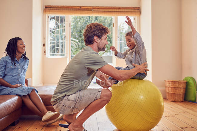 Батько і дочка грають з фітнес-кулькою — стокове фото