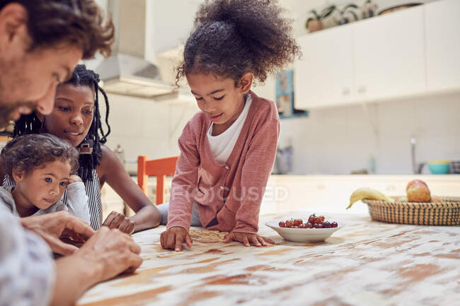 Familia joven jugando scrabble juego de palabras en la mesa - foto de stock