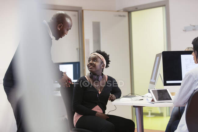 Community college instructor and student talking in computer lab classroom — Stock Photo