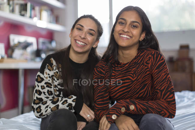 Porträt lächelt selbstbewusste Teenager-Freundinnen auf dem Bett — Stockfoto