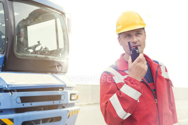Trabalhador de doca usando walkie-talkie fora do caminhão no estaleiro — Fotografia de Stock