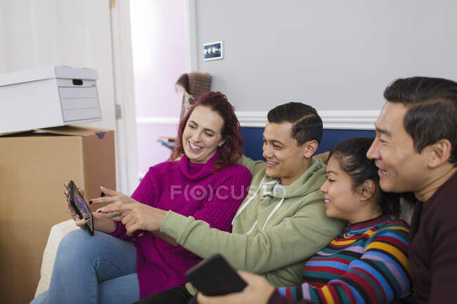 Friends taking a break from moving, using digital tablet — Stock Photo