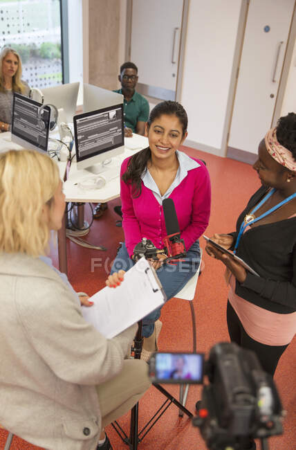 Community college journalism students at microphone in classroom — Stock Photo