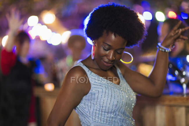 Unbekümmerte Frau mit Neonohrringen tanzt auf Party — Stockfoto