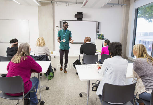 Estudantes universitários comunitários assistindo instrutor lição de liderança em sala de aula — Fotografia de Stock