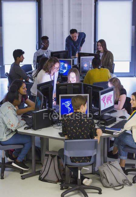 Estudiantes de secundaria y profesores usando computadoras en el laboratorio de computación - foto de stock