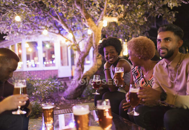 Amigos hablando y bebiendo cerveza en la fiesta del jardín - foto de stock