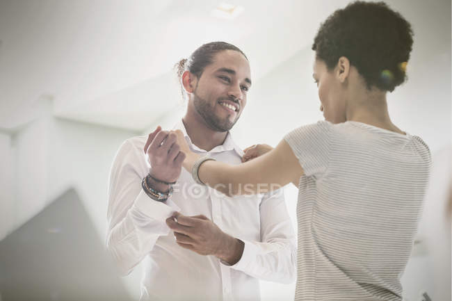 Woman helping boyfriend getting dressed, adjusting shirt collar — Stock Photo