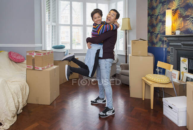 Retrato feliz, pareja juguetona mudándose a casa nueva - foto de stock