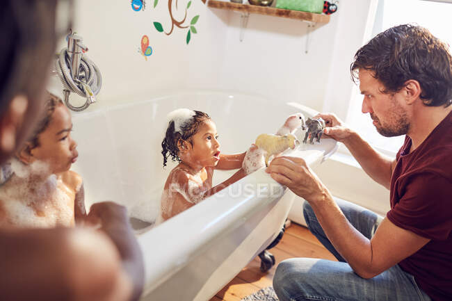 Pai e filha na banheira brincando com animais de brinquedo — Fotografia de Stock