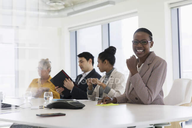 Retrato sonriente mujer de negocios en la sala de conferencias reunión - foto de stock
