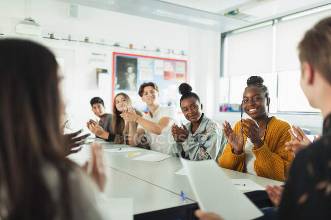 Щасливі старшокласники плескають у класі дебатів — стокове фото