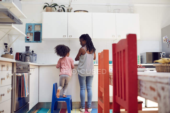 Mother and daughter doing dishes at kitchen sink — Stock Photo