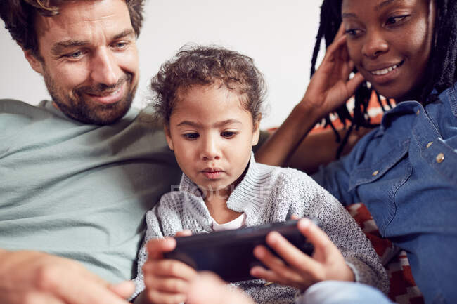 Young family using smart phone — Stock Photo