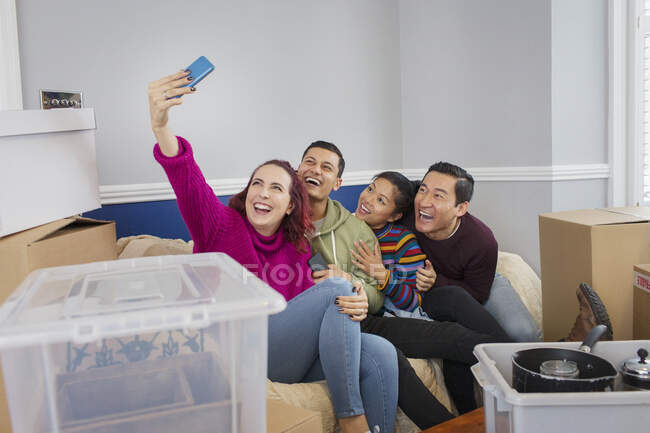 Happy friends taking a break from moving, taking selfie on sofa — Stock Photo