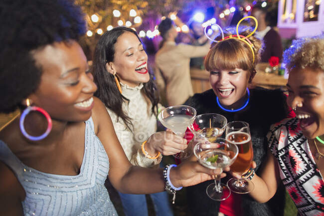 Счастливые женщины-друзья пьют коктейли на вечеринке — стоковое фото