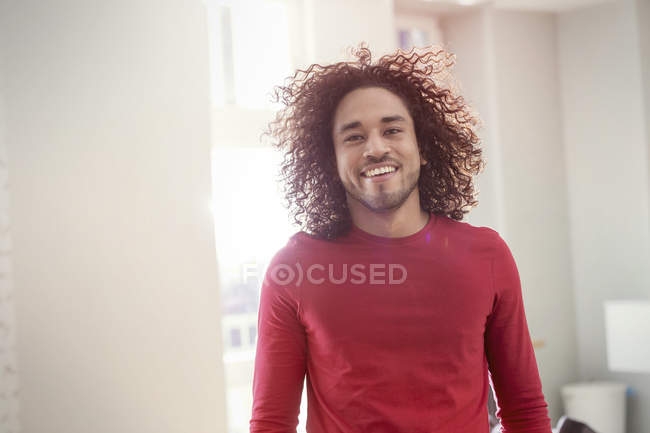 Портрет впевнений, усміхнений молодий чоловік з кучерявим волоссям — стокове фото