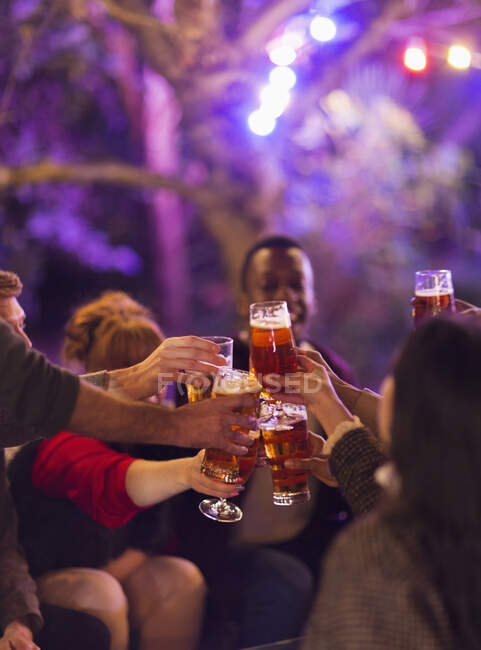 Amigos brindando copos de cerveja na festa — Fotografia de Stock