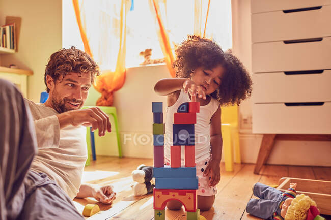 Father and daughter playing with wood blocks — Stock Photo