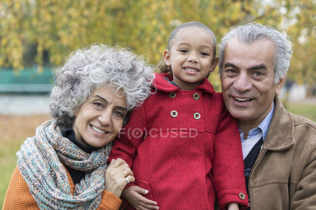 Портрет улыбающихся бабушки и дедушки с внучкой — стоковое фото