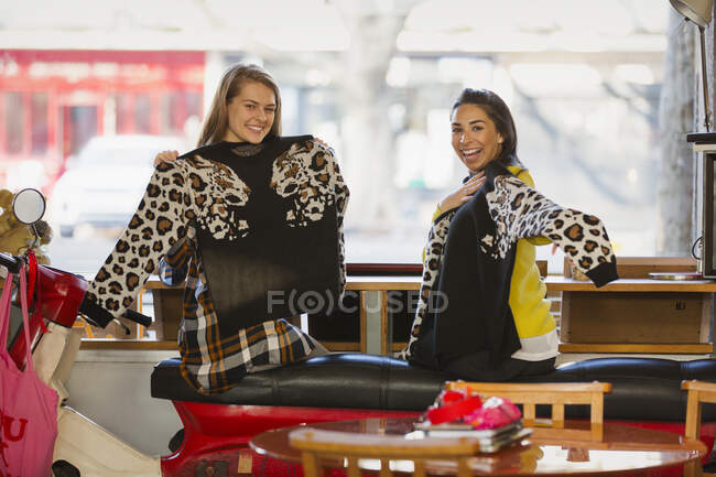 Portrait happy young women friends with matching sweaters in cafe — Stock Photo