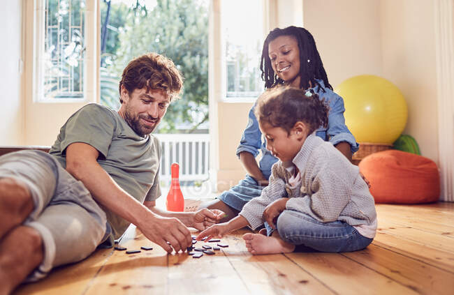 Giovane famiglia che gioca con domino sul pavimento — Foto stock