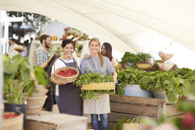 Portrait smiling women workers with vegetables in farmers market — Stock Photo