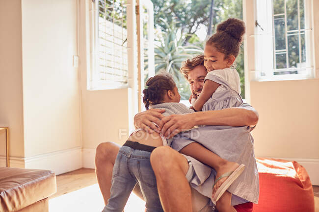 Affectionate father and daughters hugging — Stock Photo