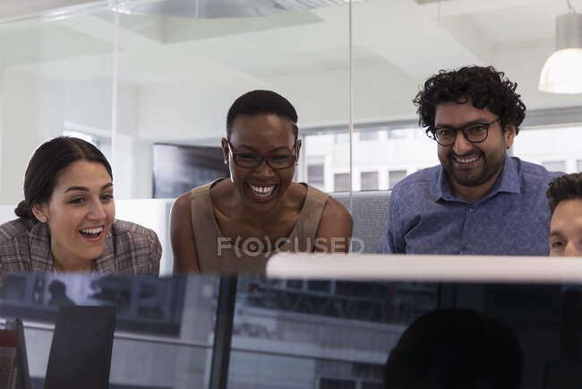 Pessoas de negócios felizes que se encontram no computador no escritório — Fotografia de Stock
