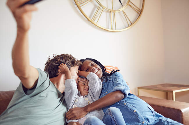 Affettuosa giovane famiglia incinta che prende selfie sul divano del soggiorno — Foto stock