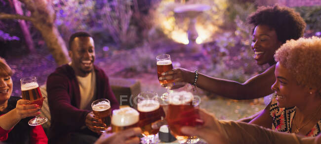Amici brindare bicchieri di birra alla festa — Foto stock