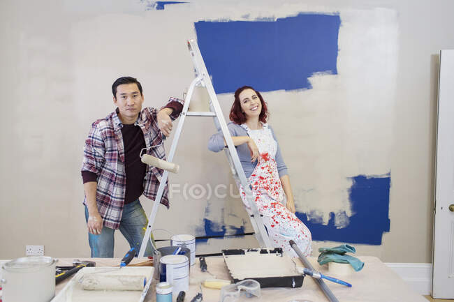 Portrait couple redecorating, painting wall — Stock Photo