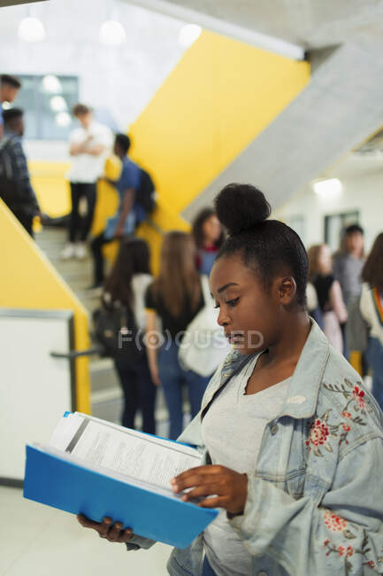 Молодша старшокласниця вчиться в коридорі. — стокове фото