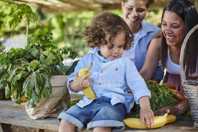 Young homosexual family shopping at farmers market — Stock Photo