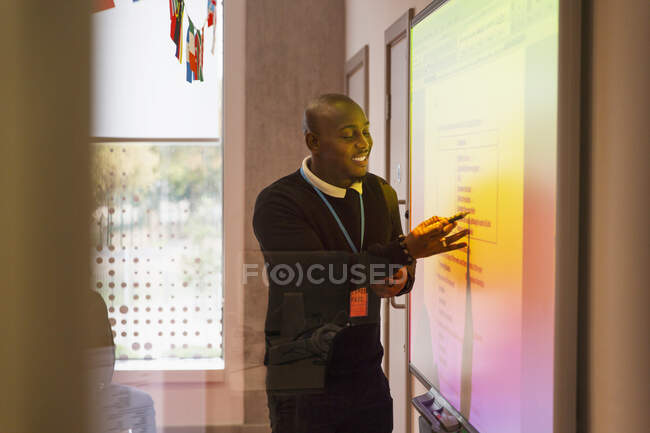 Male instructor leading lesson at projection screen in classroom — Stock Photo