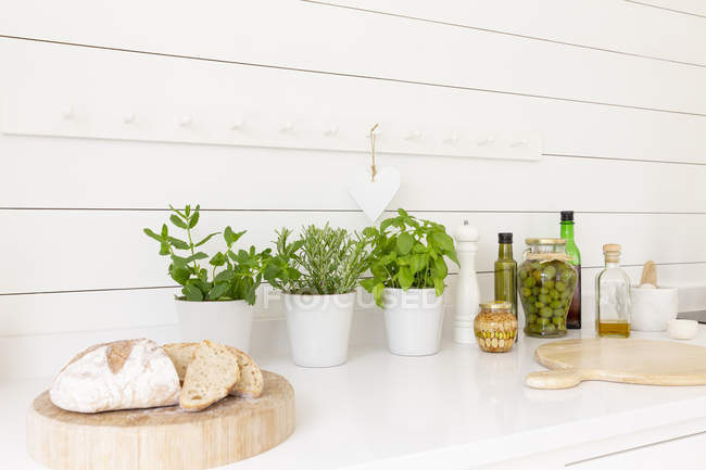 Домашній хліб, трави та оливкова олія на кухонній стільниці — стокове фото