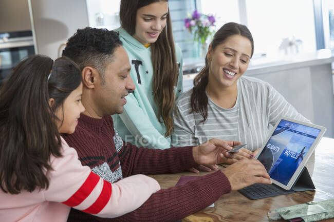 Glückliche Familienplanung und Bezahlung für den Urlaub am digitalen Tablet — Stockfoto