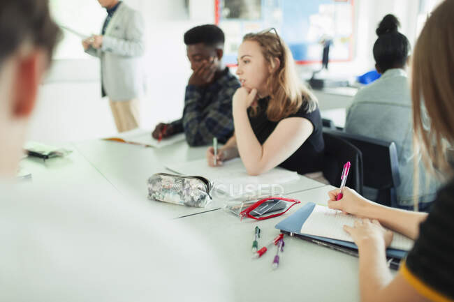 Estudantes do ensino médio estudando em mesas em sala de aula — Fotografia de Stock