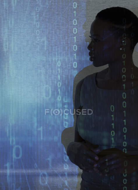 Silhouette of businesswoman against binary code on projection screen — Stock Photo