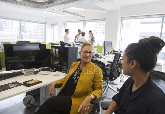 Бізнес-леді розмовляють у офісі відкритого плану — стокове фото