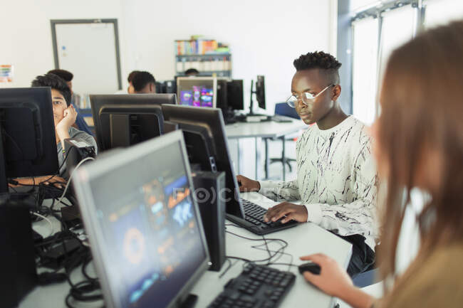 Сосредоточенный ученик средней школы с помощью компьютера в компьютерной лаборатории — стоковое фото