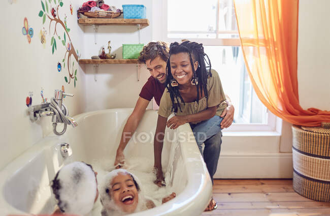Батьки дають грайливі дочки бульбашкова ванна — стокове фото
