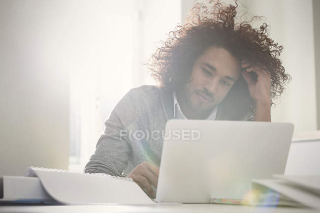 Konzentrierter junger Mann arbeitet am Laptop — Stockfoto
